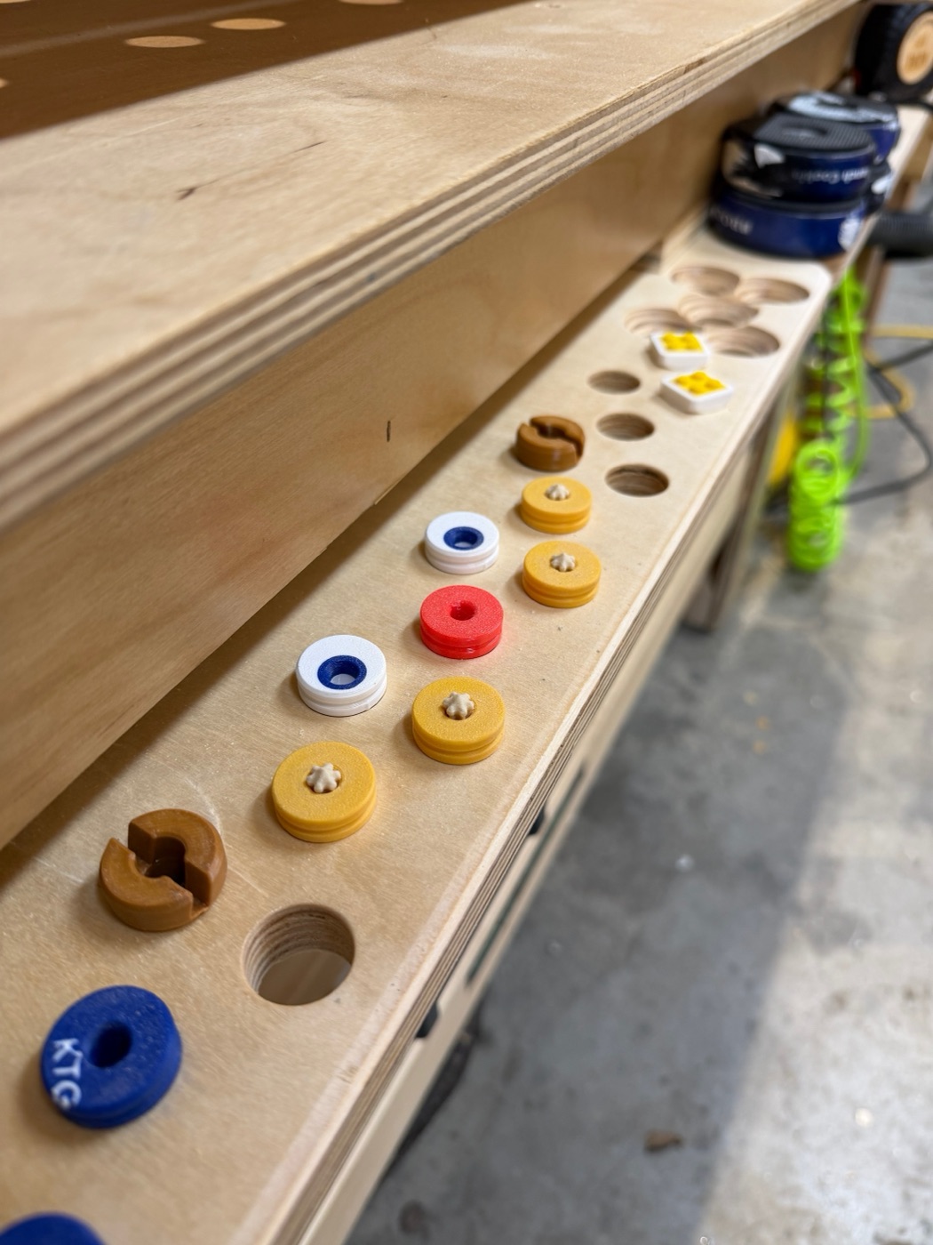 Colorful 3D-printed bench dogs in workbench