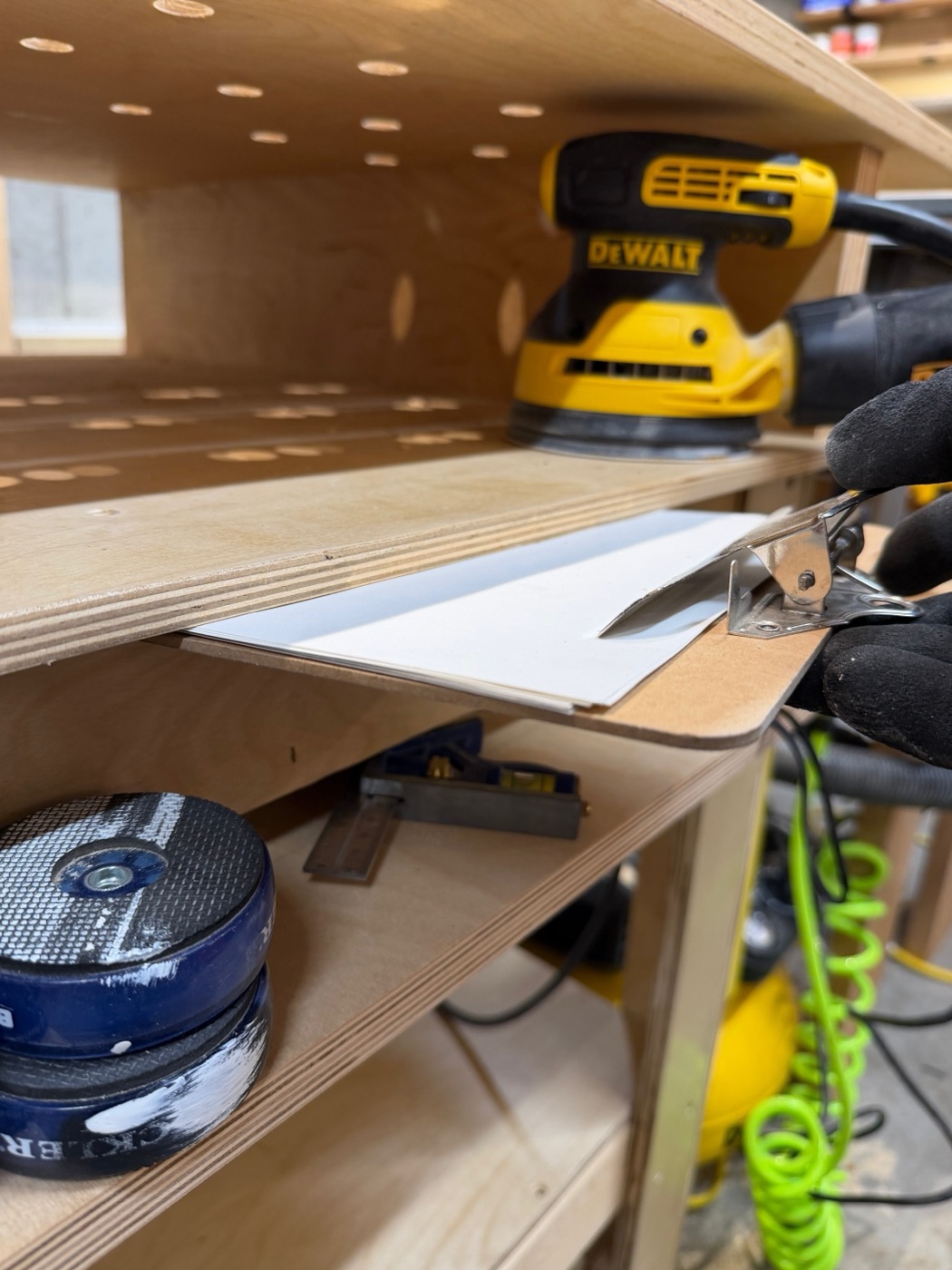 Under-bench shelving with sander and supplies