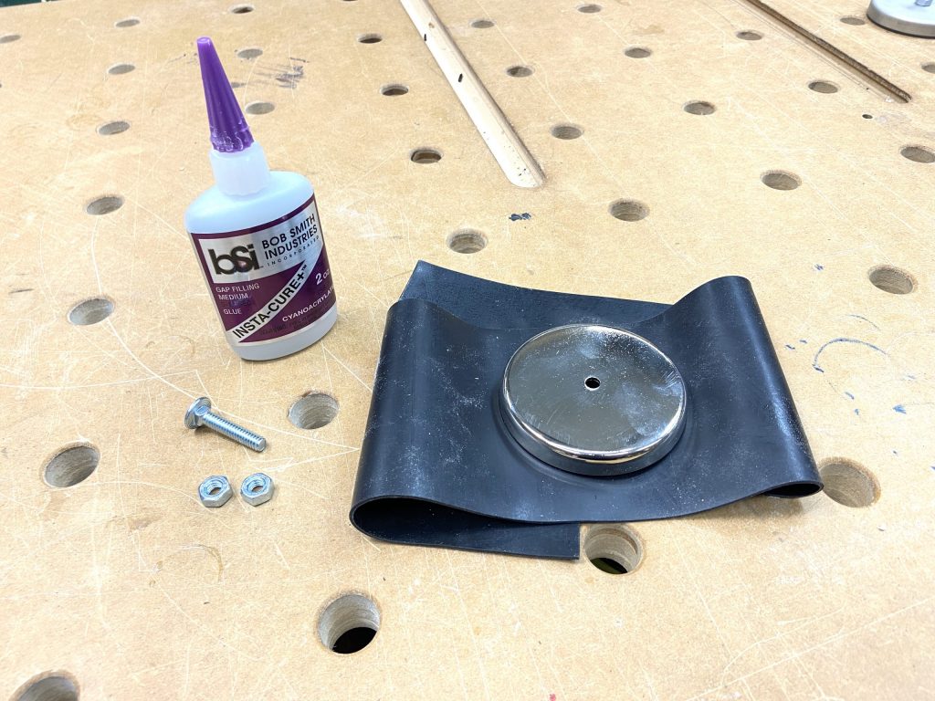 Supplies laid out: rubber, magnet, CA glue, bolts